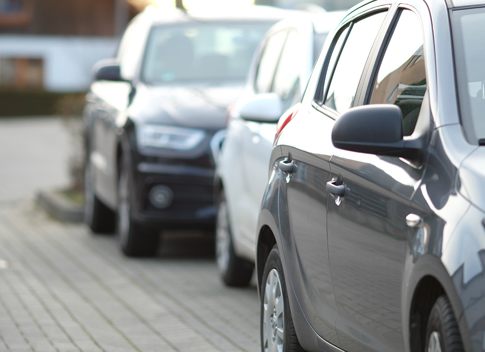 closeup-shot-black-car-parking-lot-with-blurred-background